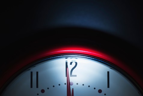 Close up of clock face showing midnight.