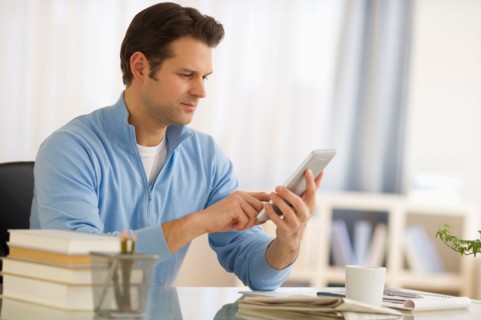 Man using digital tablet at home office.