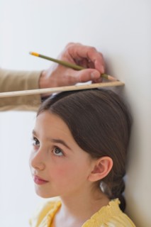Girl (8-9) being measured.