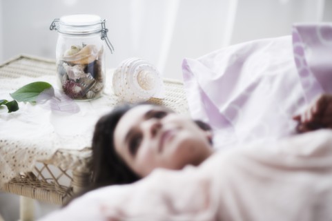 Young woman daydreaming in bed.
