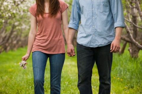 USA, Utah, Provo, Young couple walking through orchard. Photo : Mike Kemp