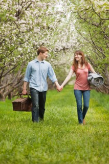 USA, Utah, Provo, Young couple with picnic basket in orchard. Photo : Mike Kemp