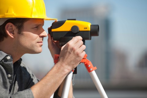Surveyor using theodolite.