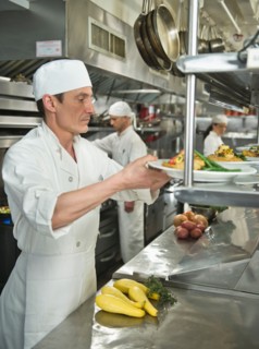 Chefs preparing food in kitchen.