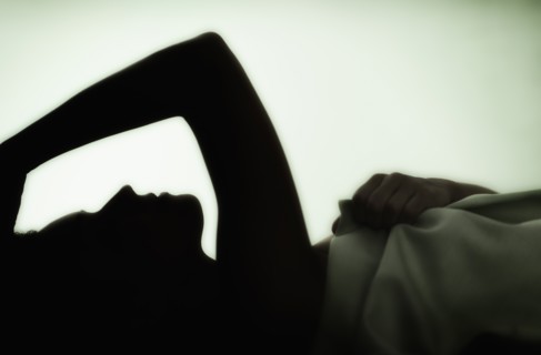 Profile of young woman lying in bed .