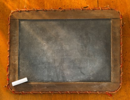Empty chalkboard with chalk, studio shot. Photo : Daniel Grill