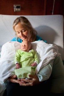 Mother with baby boy (0-1 months) on hospital bed. Photo : Noah Clayton