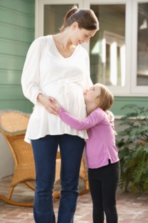 Expectant mother embracing daughter (4-5). Photo : Rob Lewine