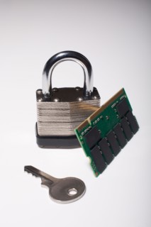 Close-up studio shot of silver padlock with key and computer chip. Photo : Winslow Productions