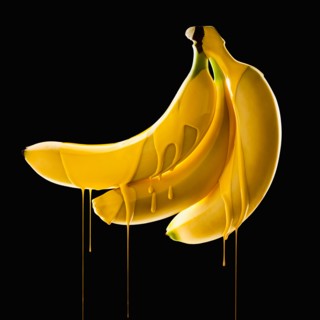 Studio shot of bananas covered with yellow paint. Photo : Mike Kemp