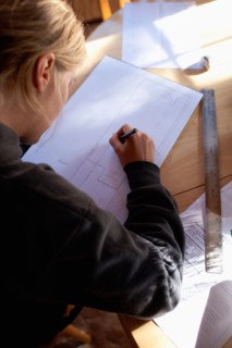 Female architect drawing plans. Photo : Noah Clayton