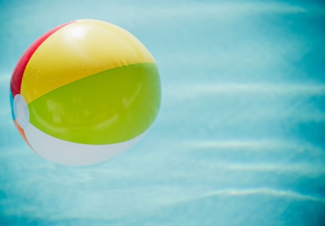 Close up of striped beach ball against water surface. Photo : Jamie Grill Photography