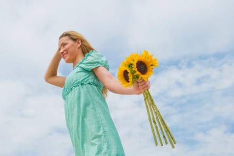 Woman holding sunflowers.