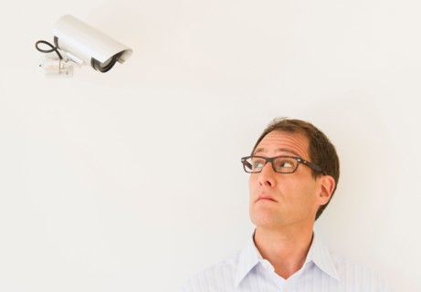 Businessman under surveillance of security camera.