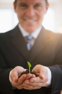 Businessman holding seedling. Photo : Jamie Grill