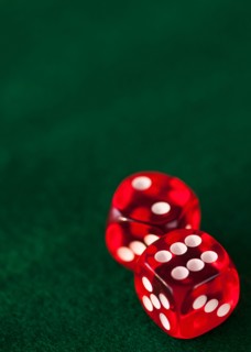 Close up of red dices on green felt. Photo : Daniel Grill