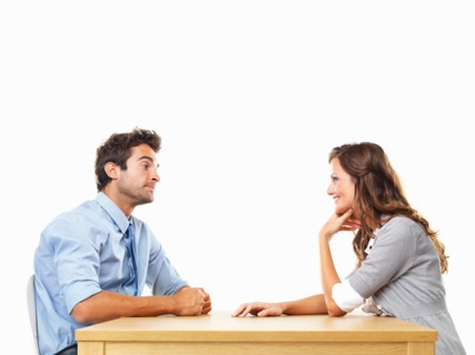 Uninterested business man and smiling business woman sitting at table for date. Photo: momentimages