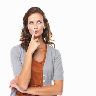 Studio portrait of woman with finger on lips. Photo: momentimages