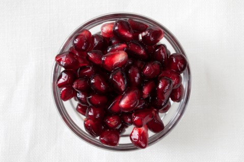 Studio shot of pomegranate (Punica granatum) seeds in bowl. Photo : Winslow Productions