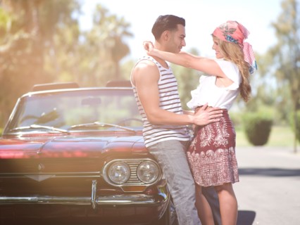 Couple embracing near convertible car. Photo : db2stock