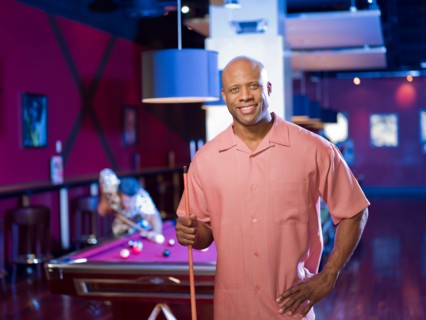 Men enjoying game of pool at bar. Photo: db2stock