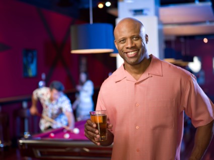 Men enjoying game of pool at bar. Photo: db2stock