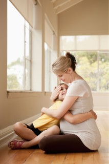 Daughter embracing (6-7) pregnant mother. Photo : Rob Lewine