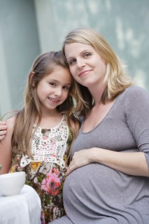 Portrait of pregnant mother and daughter (6-7)embracing. Photo : Rob Lewine