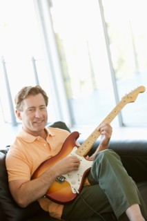 Mature man playing guitar. Photo : Rob Lewine