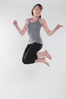 Portrait of young woman jumping, studio shot. Photo : Rob Lewine