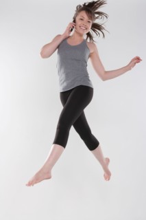 Portrait of young woman jumping, studio shot. Photo : Rob Lewine