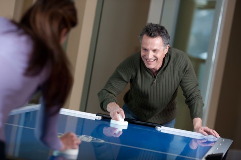Couple playing air hockey. Photo: db2stock