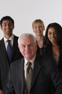 Portrait of four business people, studio shot. Photo : Rob Lewine