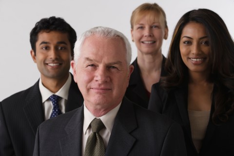 Portrait of four business people, studio shot. Photo : Rob Lewine