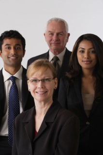 Portrait of four business people, studio shot. Photo : Rob Lewine