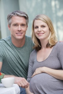 Portrait of pregnant mother and daughter (6-7)embracing. Photo : Rob Lewine
