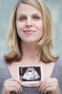 Pregnant woman holding CAT image of her belly. Photo : Rob Lewine