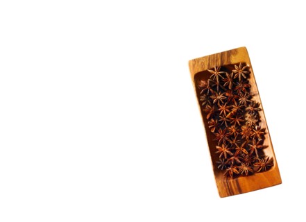 Studio shot of star anise on wooden tray. Photo : David Arky