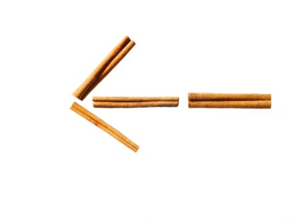 Studio shot of Cinnamon Sticks making Arrow sign on white background. Photo: David Arky