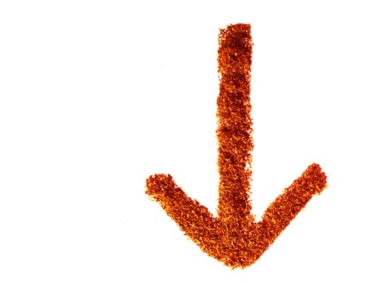 Studio shot of Red Chili Powder making arrow sign on white background. Photo : David Arky