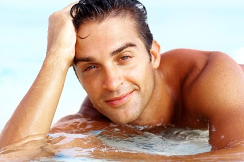 Portrait of attractive young man relaxing on beach. Photo : momentimages