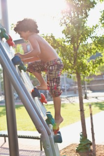 USA, New York State, New York City, Brooklyn, Boy (6-7) climbing up jungle gym. Photo: Johannes