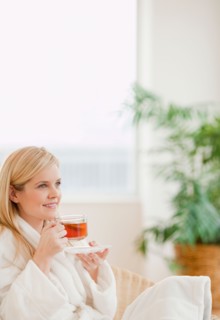 Young woman in bathrobe drinking tea. Photo : Jamie Grill