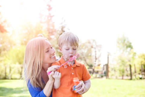 Mother and son (2-3) blowing bubbles in park. Photo : Take A Pix Media