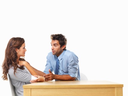 Business couple sitting at table and talking to each other. Photo : momentimages