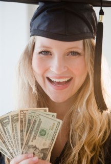 Young woman wearing graduation gown holding banknotes. Photo : Jamie Grill