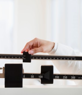 Close up of female doctor's hand holding scale. Photo: Jamie Grill