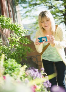 USA, Brooklyn, Williamsburg, Woman photographing flowers. Photo : Jamie Grill