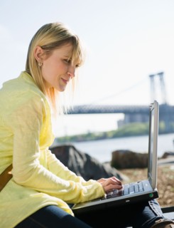USA, Brooklyn, Williamsburg, Woman using laptop. Photo : Jamie Grill