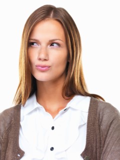 Studio portrait of beautiful business woman looking away with lips pursed. Photo : momentimages